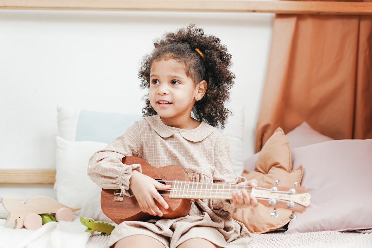 Young Girl Playing The Ukulele